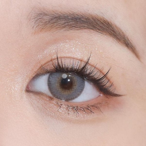 Close-up shot of an eye wearing Say Yes Spotlight Gray lenses, showcasing their elegant gray color with details.