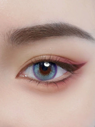 Close-up of a model wearing Metafantasia Blue contact lenses, featuring vibrant blue tones with a subtle purple ring for a futuristic look.