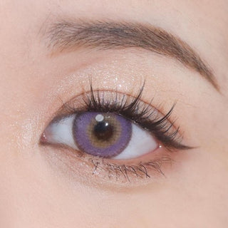 Close-up shot of an eye wearing Say Yes Nightout Violet lenses, showcasing their rich violet tones with a hint of golden highlights.